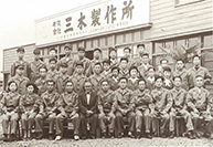 三木プーリの沿革写真 三木製作所として新たに出発した当時の社員集合写真（社屋前に整列した工場員と役員の姿）