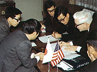 三木プーリの沿革写真 ラブジョイ社との交渉風景（机上に日米の国旗を置き軸継手分野の協業について協議する様子）